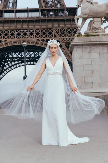 femme dans une robe de mariée sirène glamour avec un voile plissé à Paris
