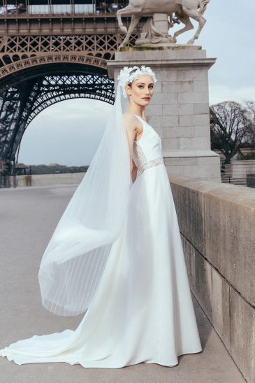 femme dans une robe de mariée sirène glamour avec un voile plissé à Paris