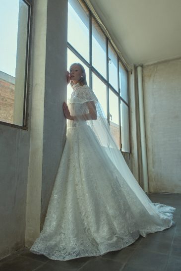 femme habillée d'une robe de mariée princesse brillante, accompagnée d'une jolie cape