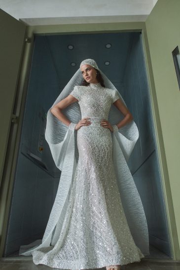 femme habillée d'une robe de sirène glamour manche courte à strass, accessoirisée d'une étole accrochée au bonnet et aux poignets