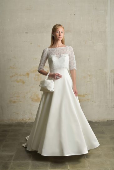 femme habillée d'une robe de mariée princesse élégante, agrémentée d'un joli top de mariée et d'un sac à main