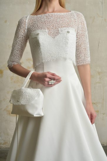 femme habillée d'une robe de mariée princesse élégante, agrémentée d'un joli top de mariée et d'un sac à main