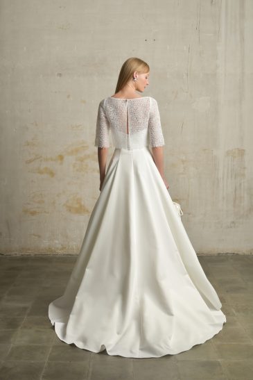 femme habillée d'une robe de mariée princesse élégante, agrémentée d'un joli top de mariée et d'un sac à main