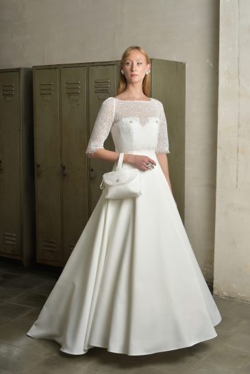 femme habillée d'une robe de mariée princesse élégante, agrémentée d'un joli top de mariée et d'un sac à main
