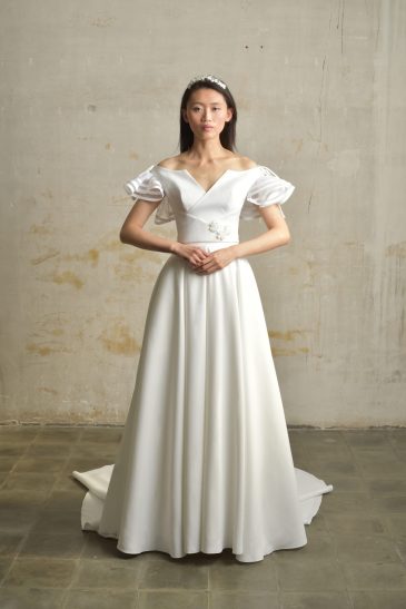 femme dans une robe de mariée princesse en taffetas broché dans un studio