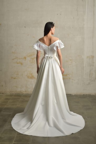 femme dans une robe de mariée princesse en taffetas broché dans un studio