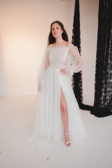femme dans une robe de mariée bohème à manches longues