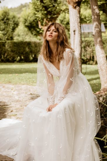 femme dans une robe de mariée bohème élégante en tulle brodé
