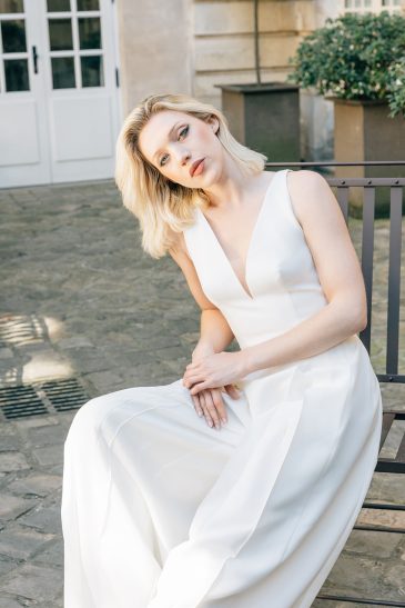 femme dans une combinaison de mariée A-line épurée en crêpe