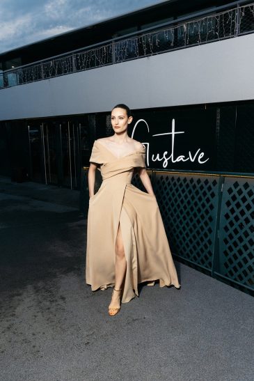 femme à Paris habillée d'une robe du soir élégante, longue à fente
