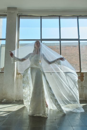 femme dans une robe de mariée glamour avec une surjupe originale à traîne et un joli voile