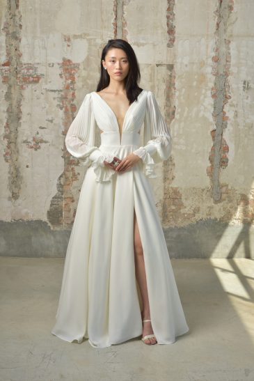femme dans une robe de mariée épurée et fluide avec des manches longues amovibles