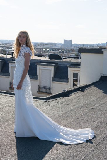 femme dans une robe de mariée épurée avec un manteau de guipure