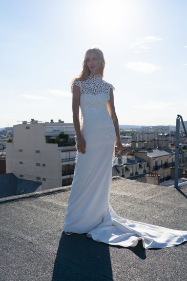 femme dans une robe de mariée épurée avec un manteau de guipure