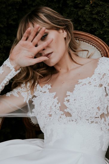 femme avec une robe de mariée princesse à manches longues en dentelle et en mikado