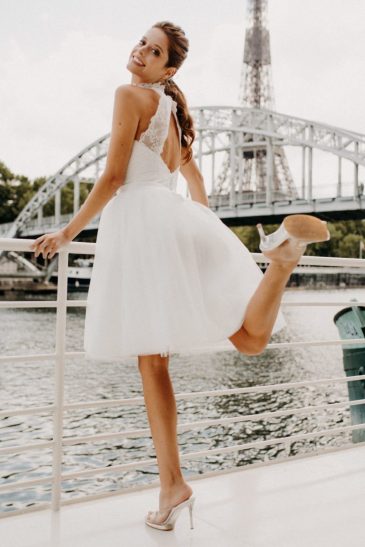 femme dans une robe de mariée courte en dentelle devant la Seine à Paris