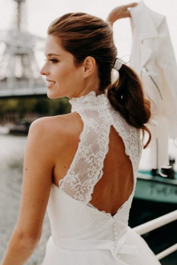 femme dans une robe de mariée courte en dentelle devant la Seine à Paris