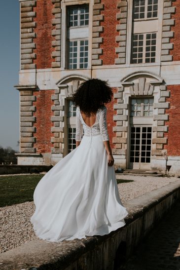 femme avec une robe de mariée bohème chic à manches longues en dentelle de Calais-Caudry