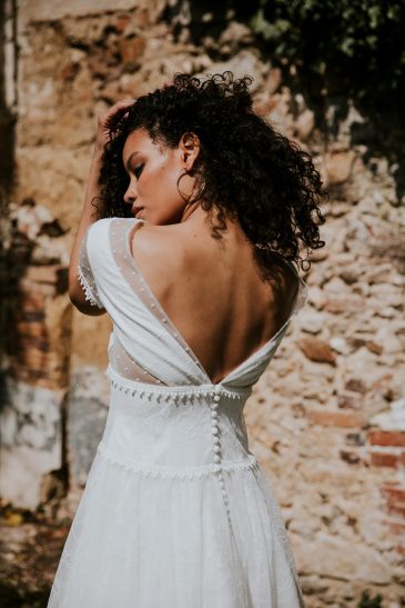 femme avec une robe de mariée courte bohème chic en dentelle et en plumetis