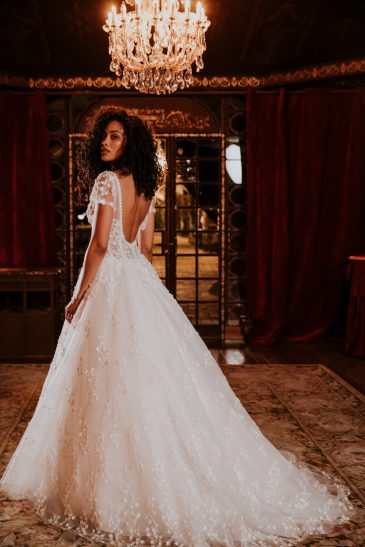 femme avec une robe de mariée princesse et brillante dans un château