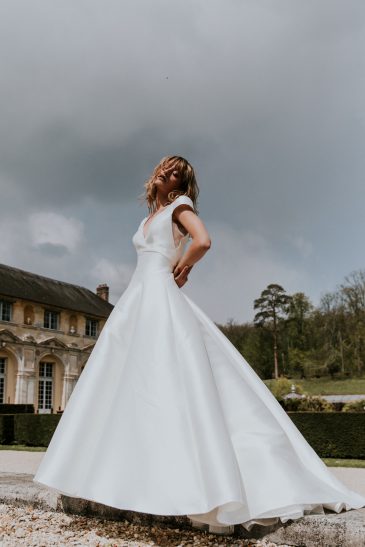 femme avec une robe de mariée princesse en mikado dans un château