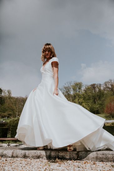 femme avec une robe de mariée princesse en mikado dans un château