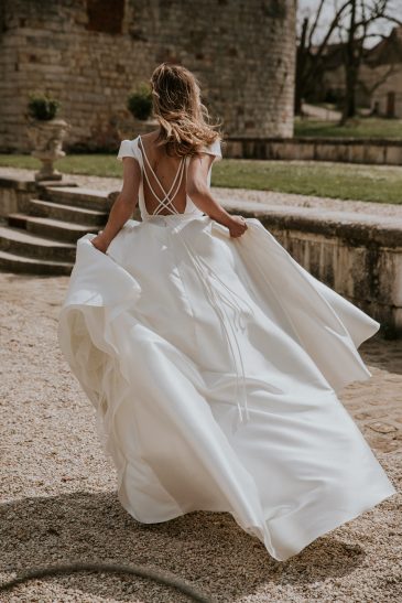 femme avec une robe de mariée princesse en mikado dans un château