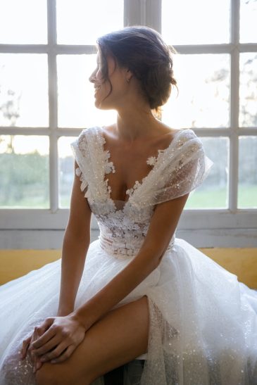 femme dans une robe de mariée brillante dans un château