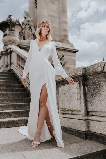 femme dans une robe de mariée épurée à manches longues à Paris