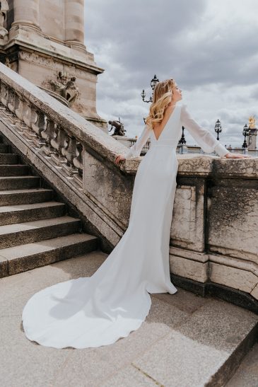 femme dans une robe de mariée épurée à manches longues à Paris