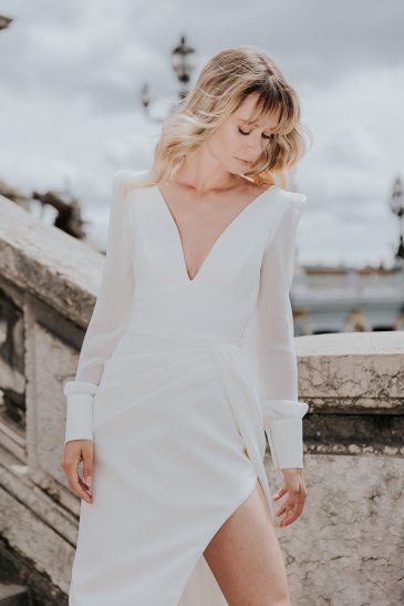 femme dans une robe de mariée épurée à manches longues à Paris