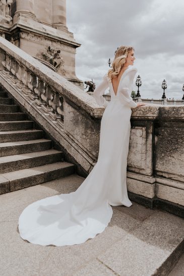 femme dans une robe de mariée épurée à manches longues à Paris