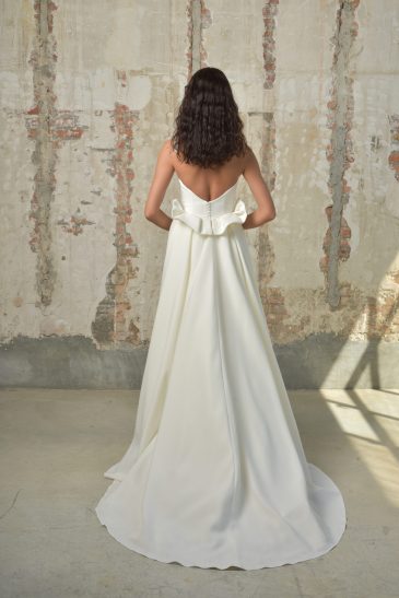 femme dans une robe de mariée sirène glamour avec une surjupe à traîne dans un studio