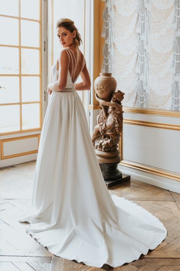 femme avec une robe de mariée épurée à bretelles dans un château