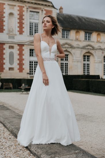 femme avec une robe de mariée fluide et épurée dans un château