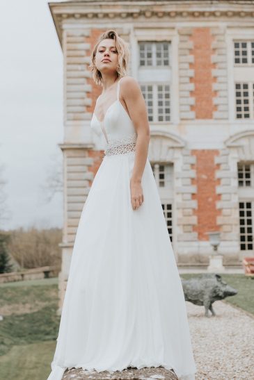 femme avec une robe de mariée fluide et épurée dans un château