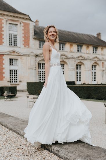 femme avec une robe de mariée fluide et épurée dans un château