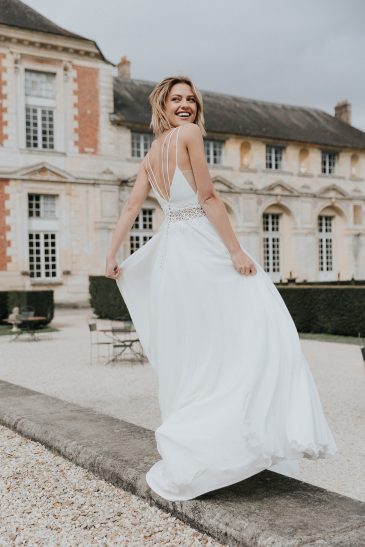 femme avec une robe de mariée fluide et épurée dans un château