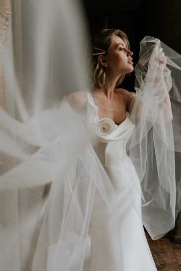 femme avec une robe de mariée glamour et épurée en mikado dans un château