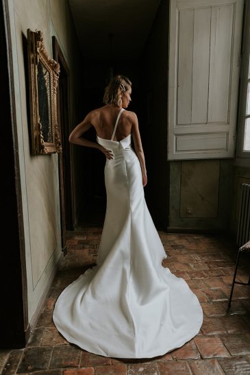 femme avec une robe de mariée glamour et épurée en mikado dans un château