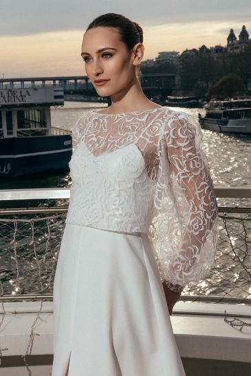 femme à Paris dans une robe de mariée épurée avec un top court brodé