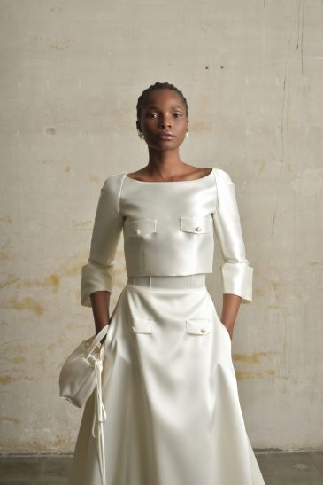 femme habillée d'une tenue de mariée raffinée composée d'un top court et une jupe longues avec des détails de poches