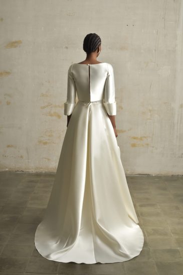 femme habillée d'une tenue de mariée raffinée composée d'un top court et une jupe longues avec des détails de poches
