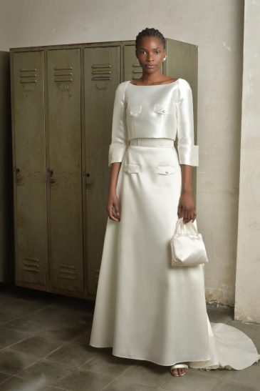 femme habillée d'une tenue de mariée raffinée composée d'un top court et une jupe longues avec des détails de poches