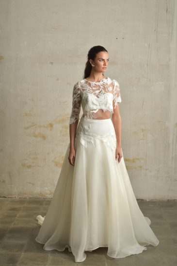 femme habillée d'une tenue de mariée composée d'une jules longue et volumineuse, d'un top bandeau et d'un top court en raphia