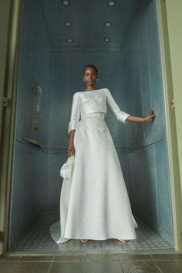 femme habillée d'une tenue de mariée raffinée composée d'un top court et une jupe longues avec des détails de poches