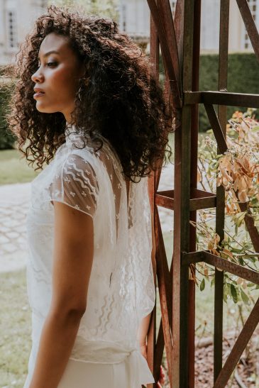 femme avec un top de mariée en dentelle dans un parc