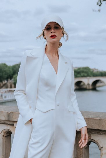 femme blonde avec une casquette et un manteau blanc